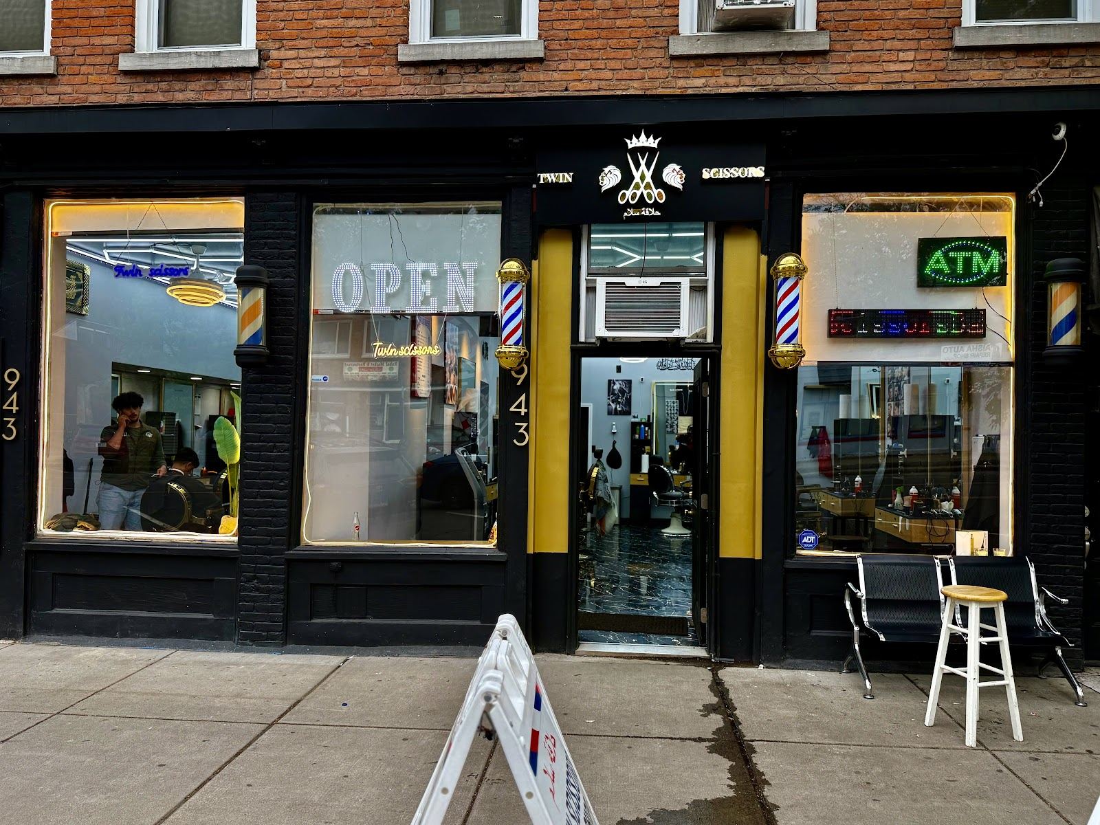 Twin Scissors Barber Shop storefront at 943 N Salina St, with barber poles and an OPEN sign